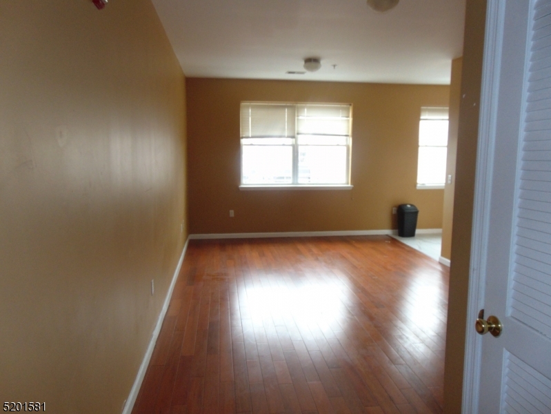25 Cottage Street, Unit 1 Newark, NJ 07102 - Photo 4 of 9 an empty room with wooden floor and windows