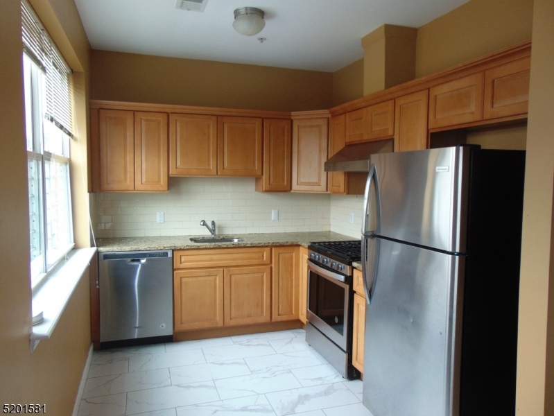 25 Cottage Street, Unit 1 Newark, NJ 07102 - Photo 5 of 9 a kitchen with stainless steel appliances granite countertop a refrigerator sink and cabinets