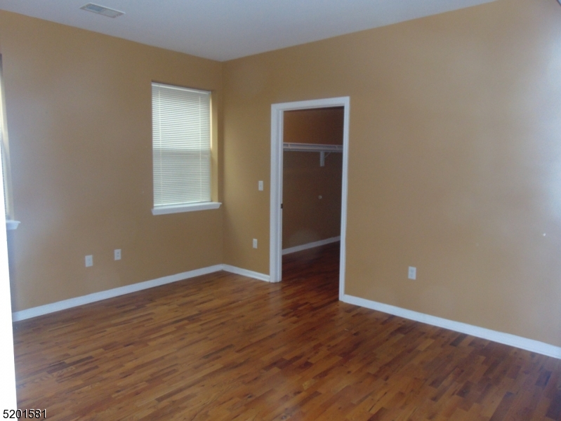 25 Cottage Street, Unit 1 Newark, NJ 07102 - Photo 8 of 9 an empty room with wooden floor and windows