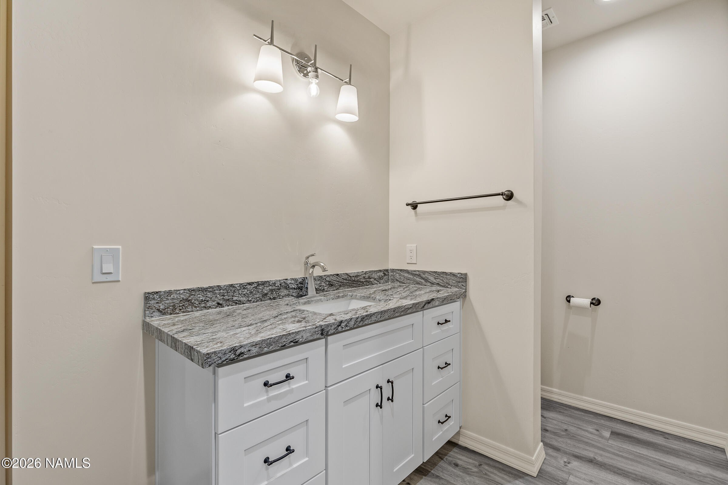 1093 Redwall Way Williams, AZ 86046 - Photo 46 of 70 a bathroom with a granite countertop sink and white cabinets