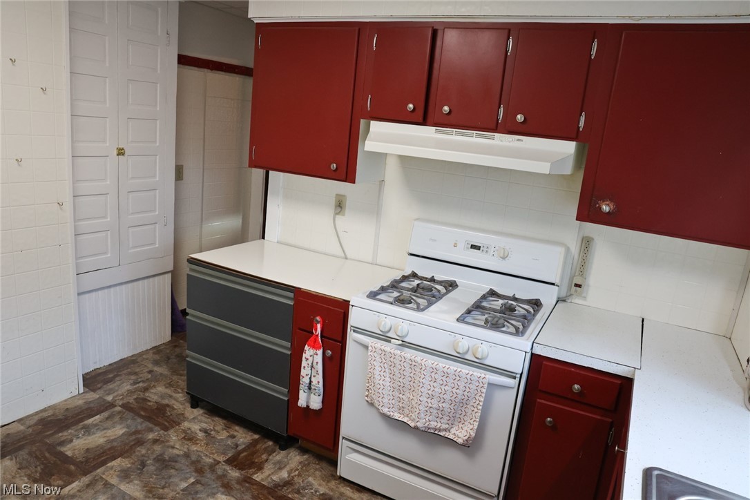 1309 Krumroy Road Akron, OH 44306 - Photo 12 of 30 Kitchen with tile walls, white gas range, and dark tile flooring