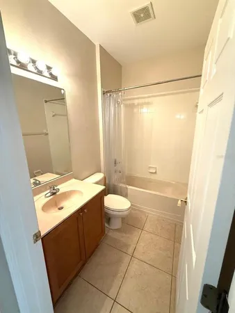 a bathroom with a granite countertop sink toilet a mirror and shower