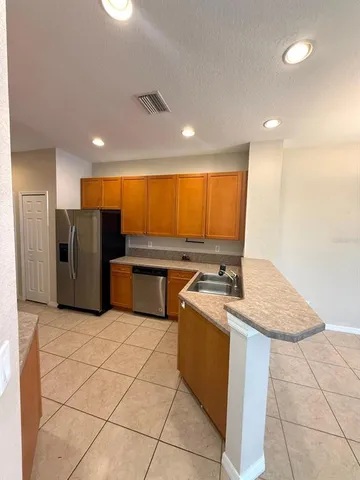 a kitchen with stainless steel appliances granite countertop a sink refrigerator and microwave