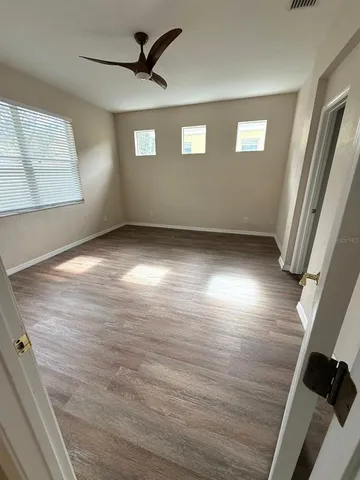 a view of a livingroom with wooden floor and a ceiling fan