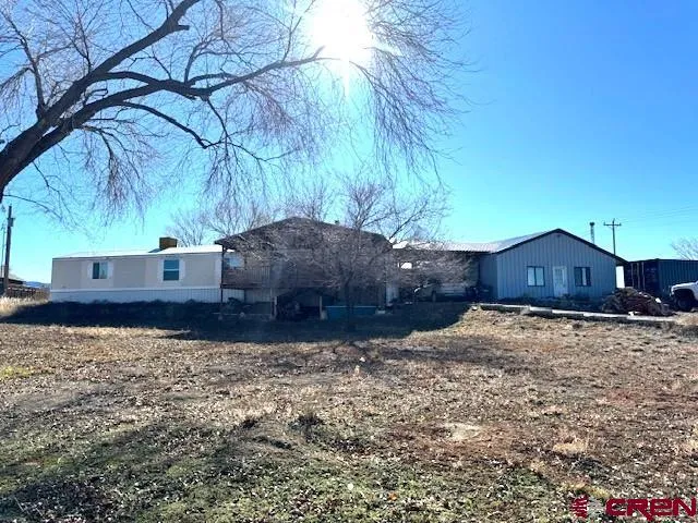 a view of a house with a yard covered with wooden fence