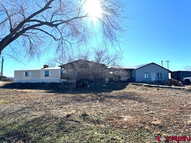 11290 Highway 145 Cortez, CO 81321 - Photo 1 of 27 a view of a house with a yard covered with wooden fence