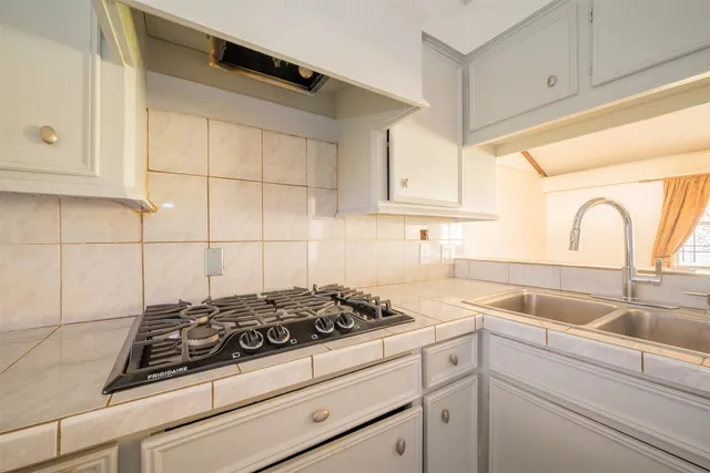 a view of a kitchen counter space a stove and a sink