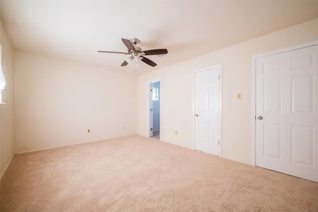 a view of a big room with closet and ceiling fan