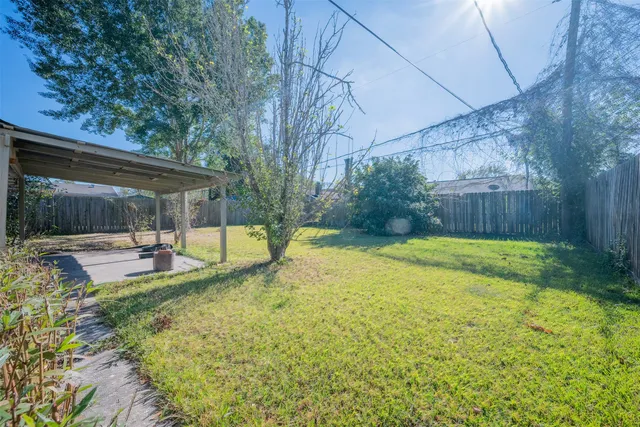 a view of a house with backyard and a tree