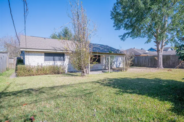 a view of a house with a yard and tree
