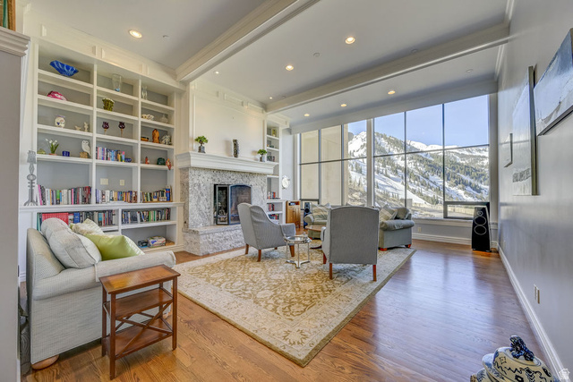 9699 Bypass Road, Unit 5 Alta, UT 84092 - Photo 13 of 54 Spacious living area featuring expansive windows, a stone fireplace, built-in shelving, hardwood flooring, and recessed lighting