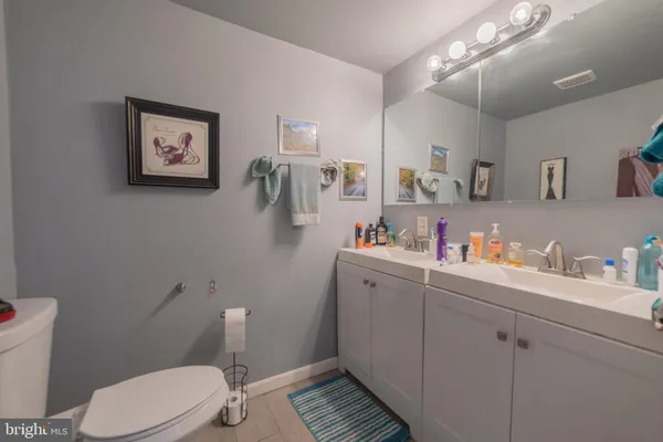 a bathroom with a sink mirror vanity and toilet