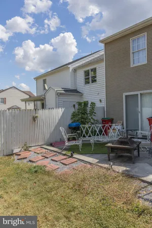 a view of a backyard with plants and a bench