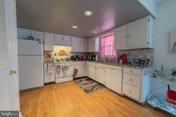 a kitchen with white cabinets and white appliances