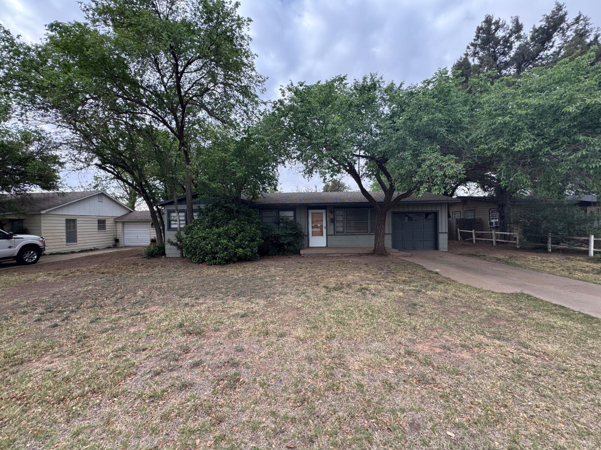 3709 23rd Street Lubbock, TX 79410 - Photo 1 of 8 a front view of a house with a garden and trees