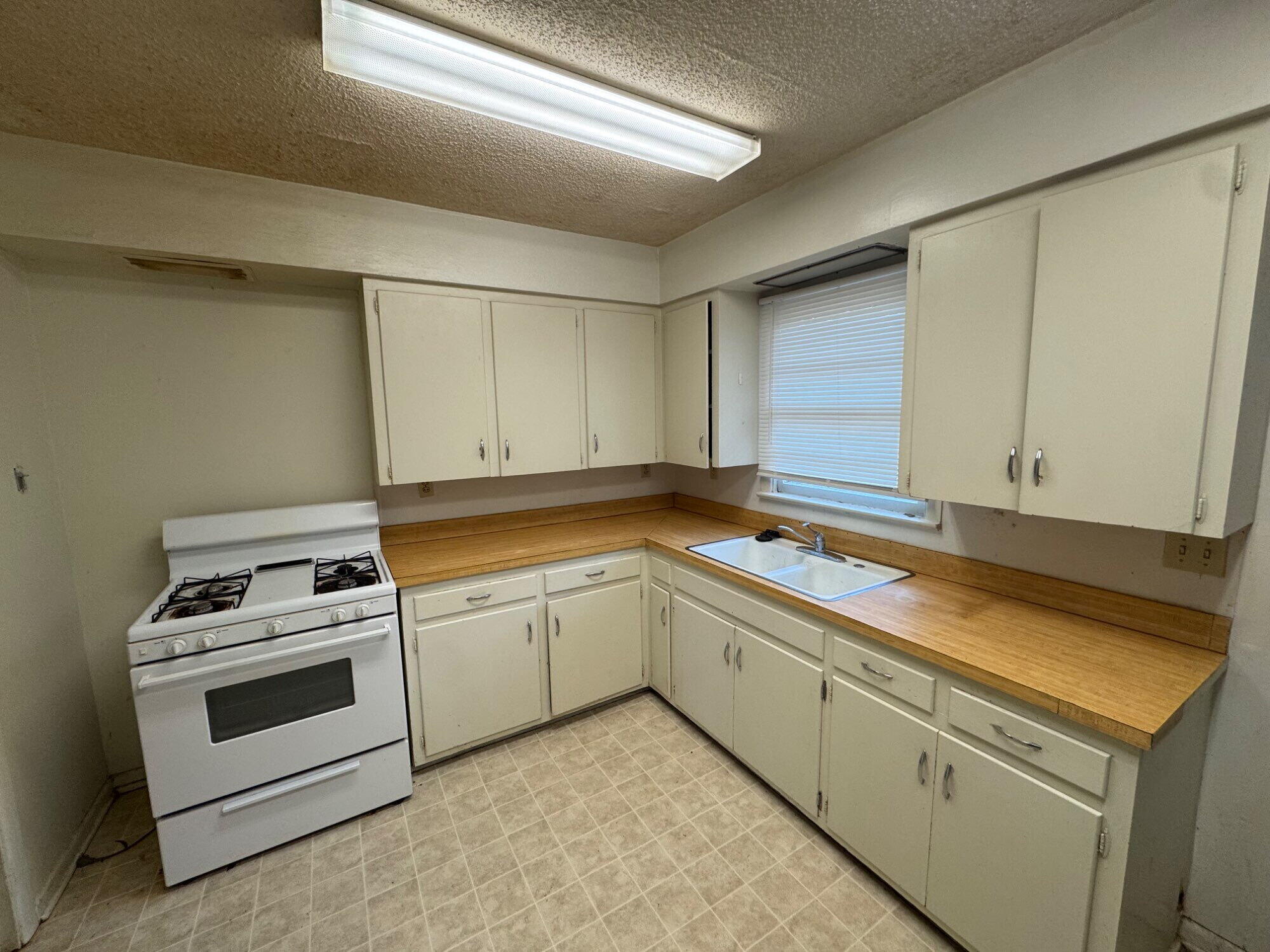 3709 23rd Street Lubbock, TX 79410 - Photo 3 of 8 a kitchen with granite countertop white cabinets and white appliances