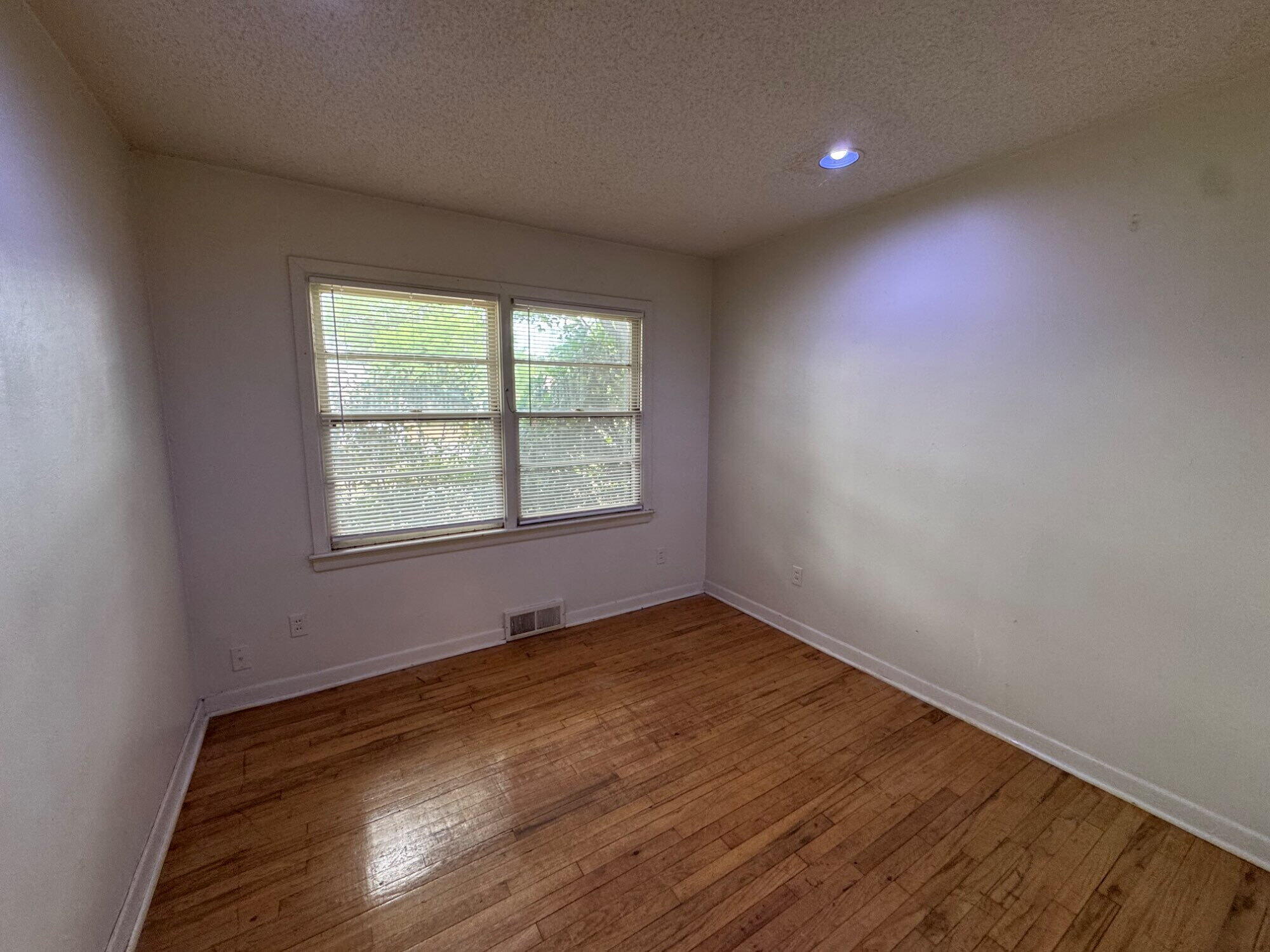3709 23rd Street Lubbock, TX 79410 - Photo 5 of 8 an empty room with wooden floor and windows