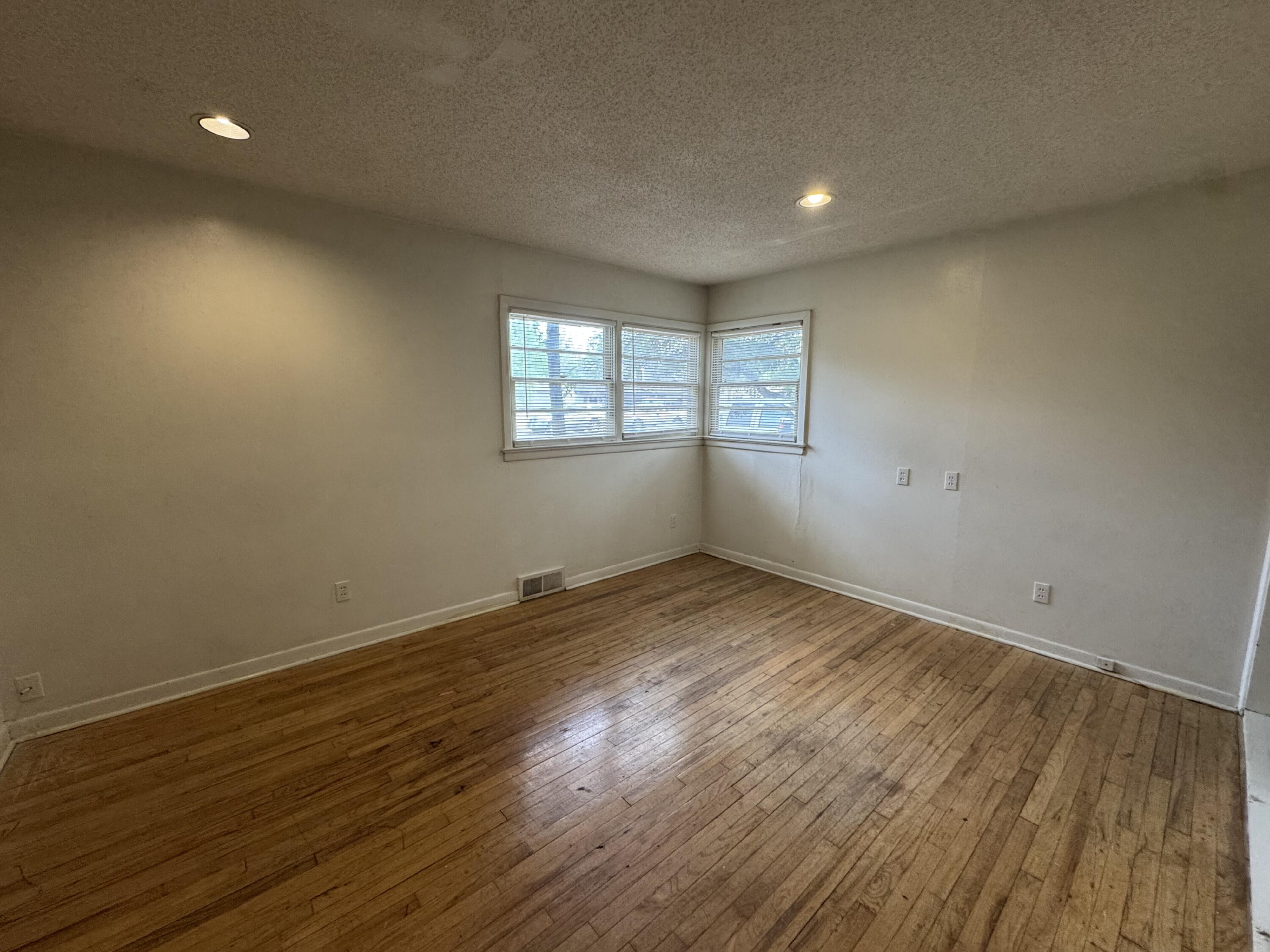 3709 23rd Street Lubbock, TX 79410 - Photo 7 of 8 an empty room with wooden floor and windows