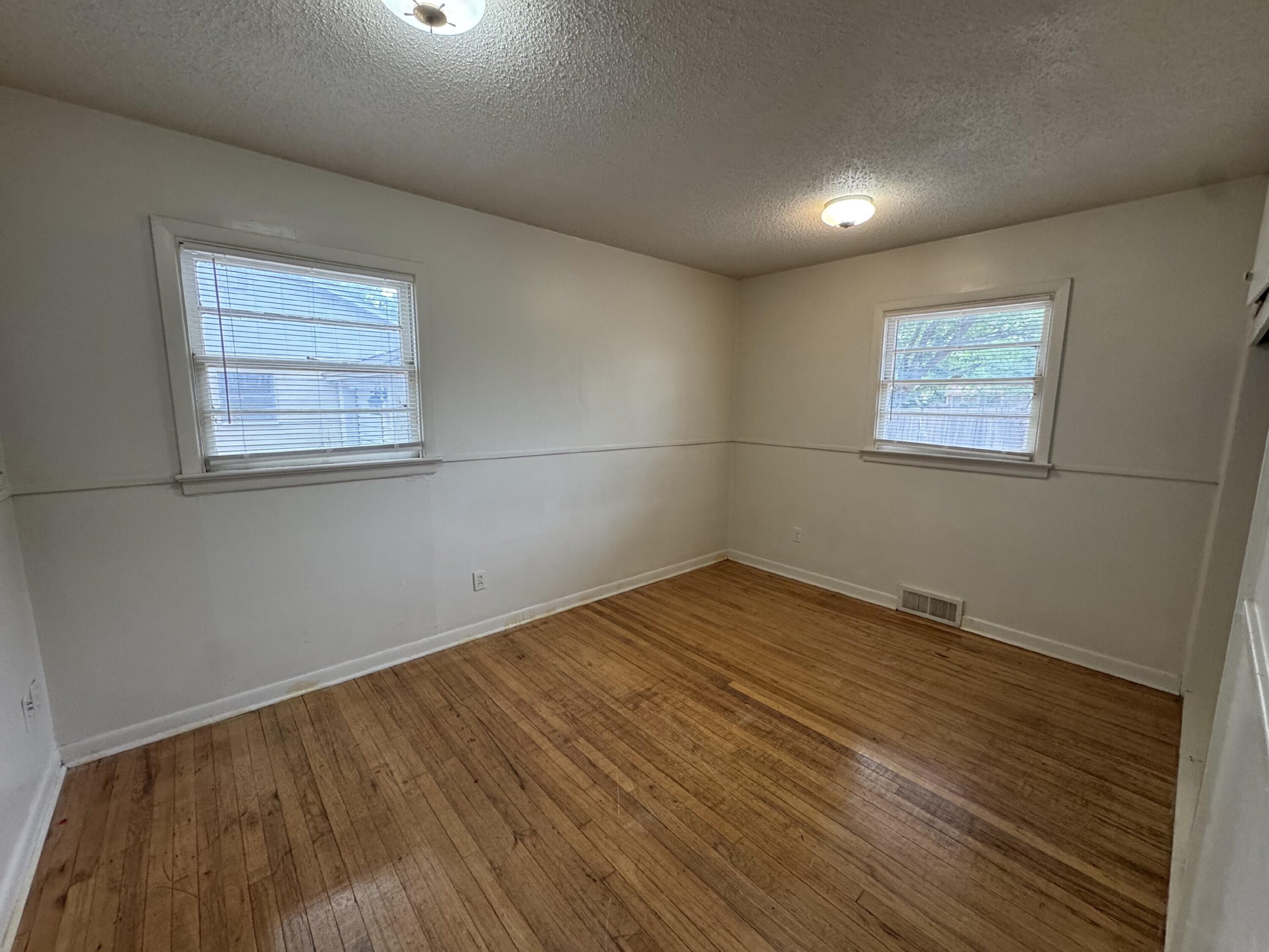 3709 23rd Street Lubbock, TX 79410 - Photo 8 of 8 an empty room with wooden floor and windows