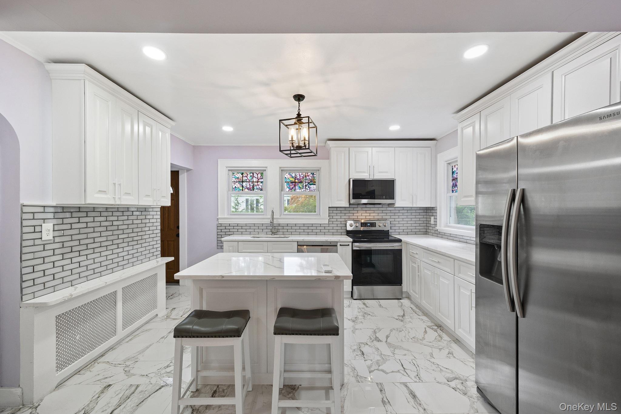 1235 Post Road Scarsdale, NY 10583 - Photo 12 of 30 Kitchen with stainless steel appliances, light marble finish floors, white cabinets, recessed lighting, and ornamental molding
