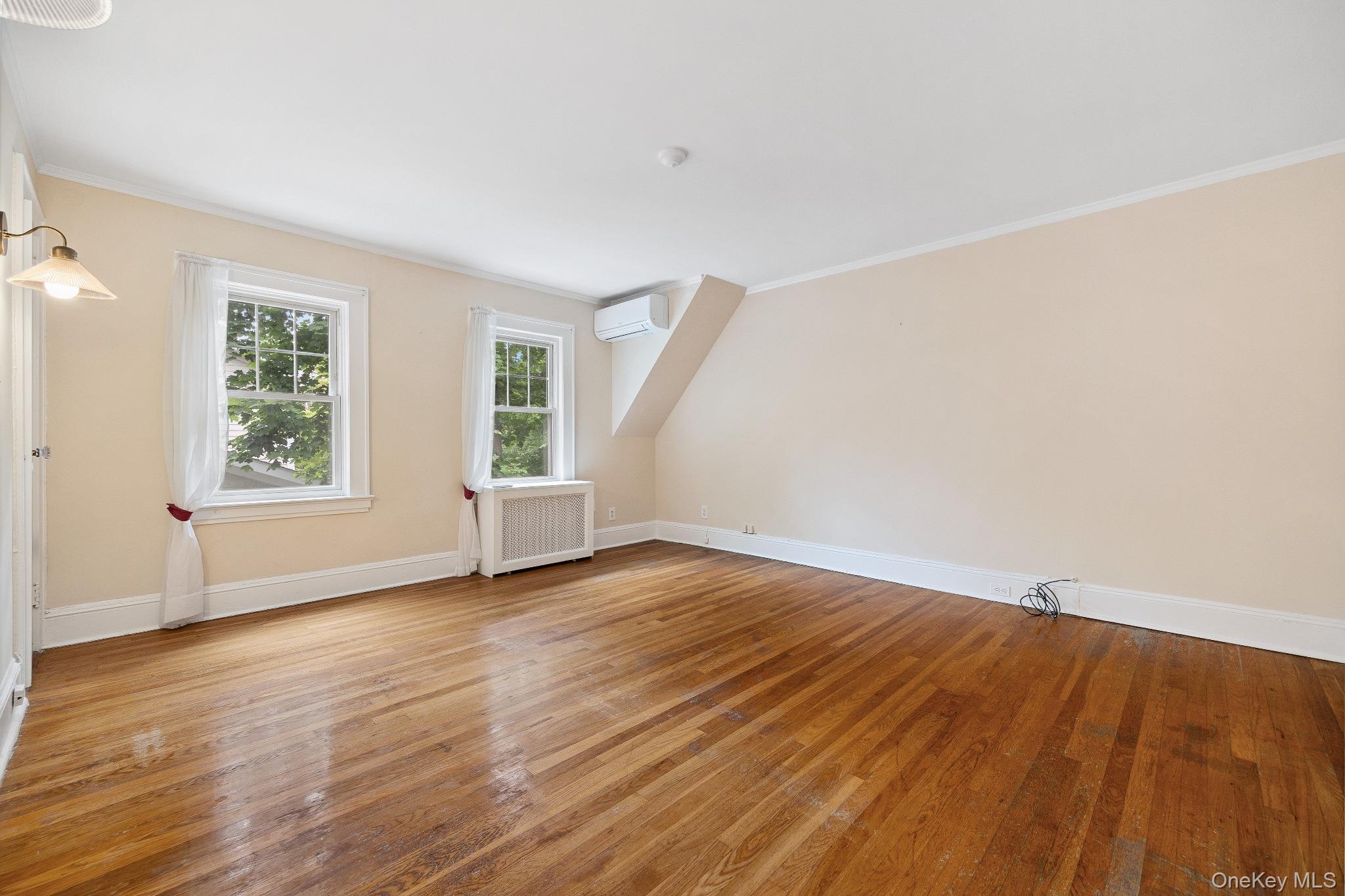1235 Post Road Scarsdale, NY 10583 - Photo 20 of 30 Bonus room with radiator heating unit, a wall mounted air conditioner, and wood finished floors
