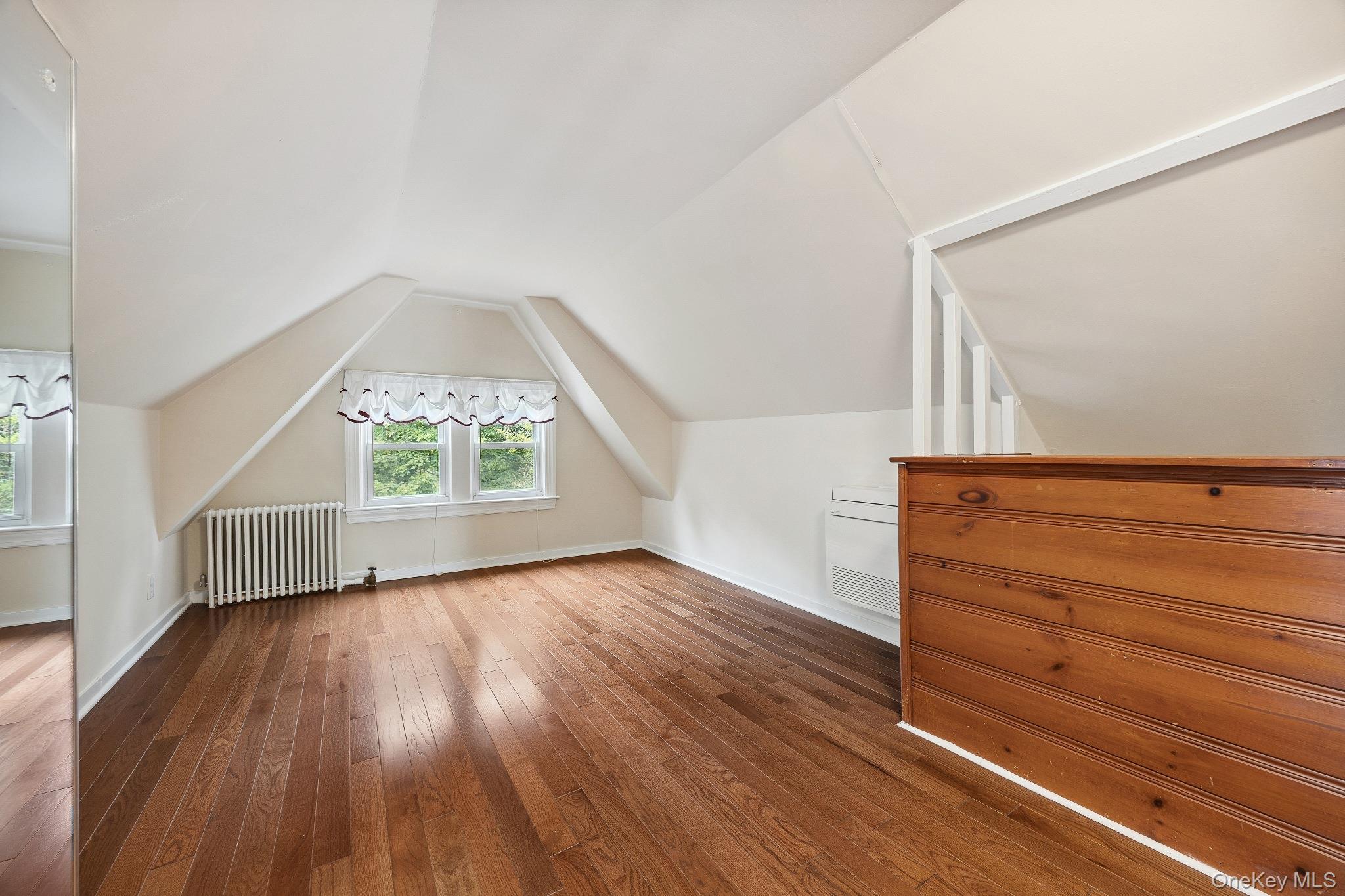 1235 Post Road Scarsdale, NY 10583 - Photo 22 of 30 Bonus room featuring radiator heating unit, dark wood finished floors, and vaulted ceiling