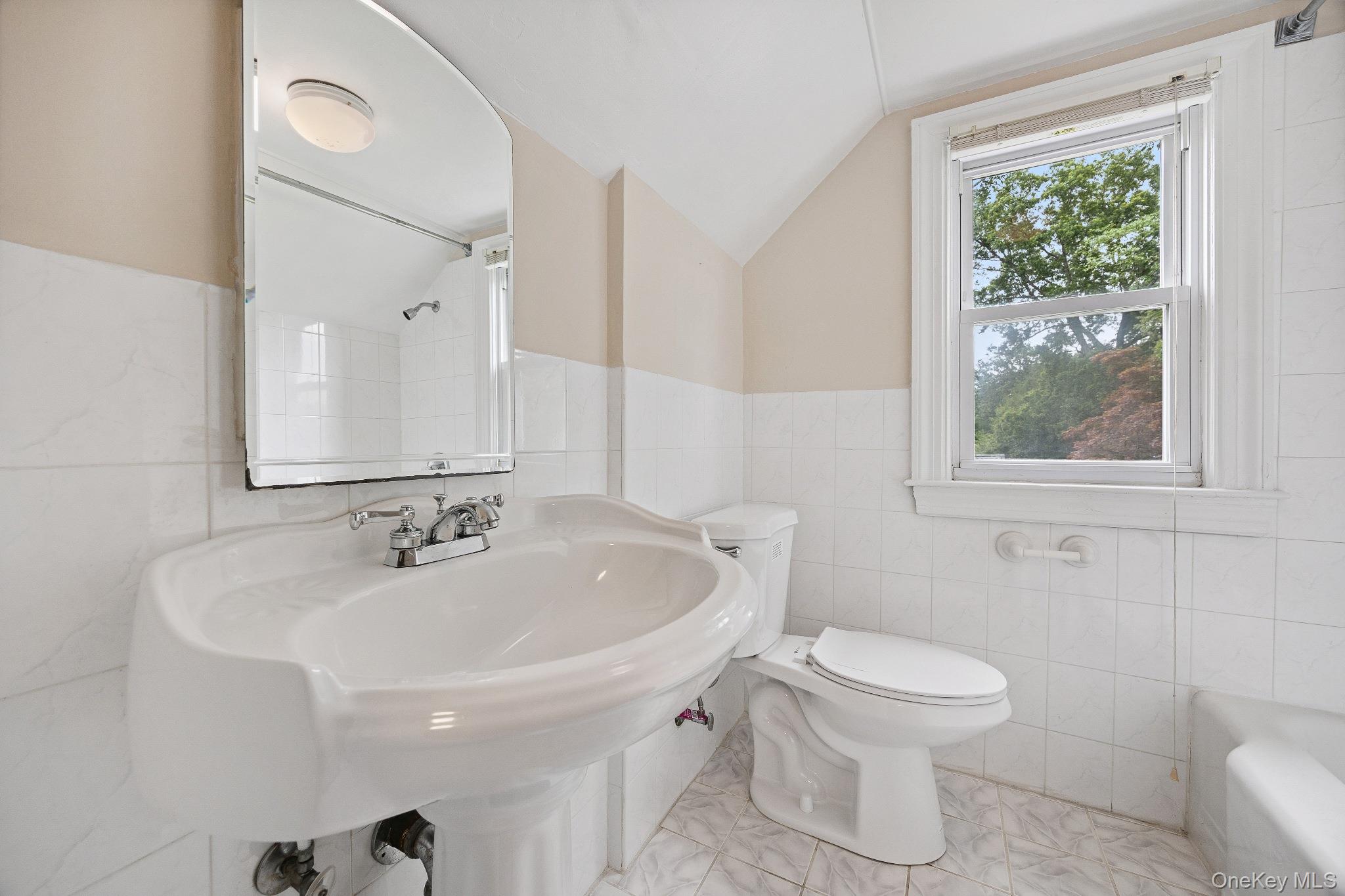 1235 Post Road Scarsdale, NY 10583 - Photo 24 of 30 Full bathroom featuring tile walls, lofted ceiling, and a bathtub
