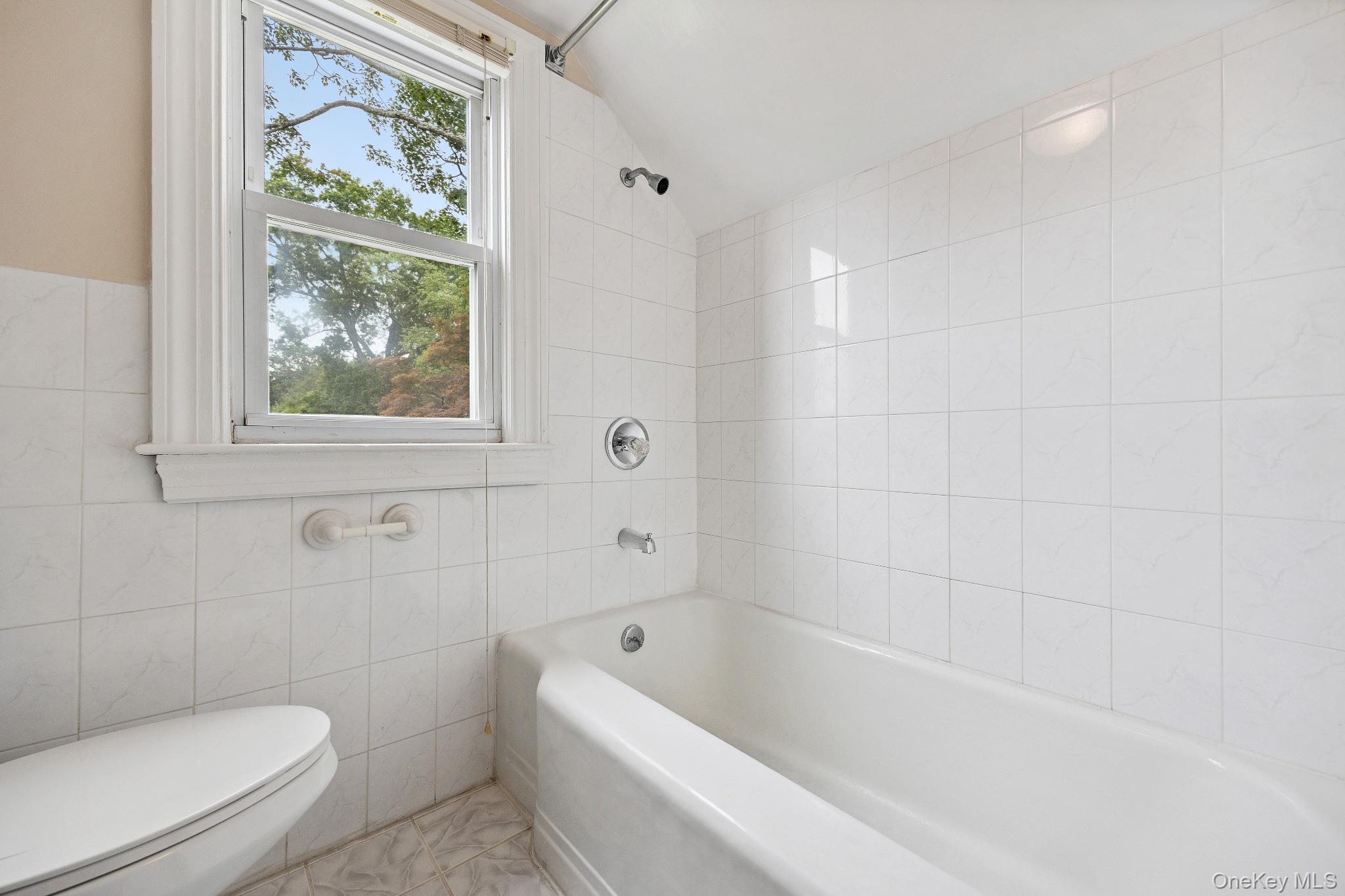 1235 Post Road Scarsdale, NY 10583 - Photo 25 of 30 Full bath with tile walls, vaulted ceiling, and bathing tub / shower combination