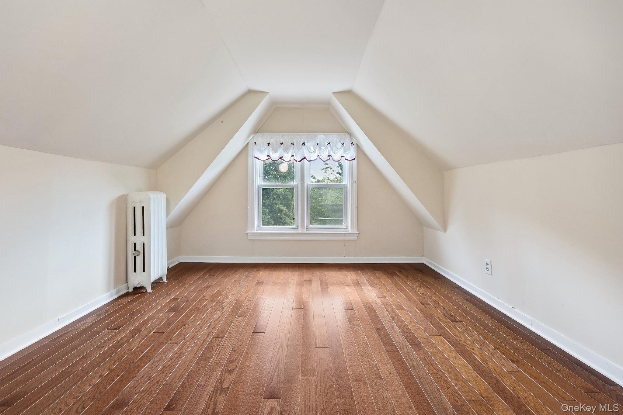 1235 Post Road Scarsdale, NY 10583 - Photo 26 of 30 Bonus room featuring radiator, hardwood / wood-style floors, and lofted ceiling