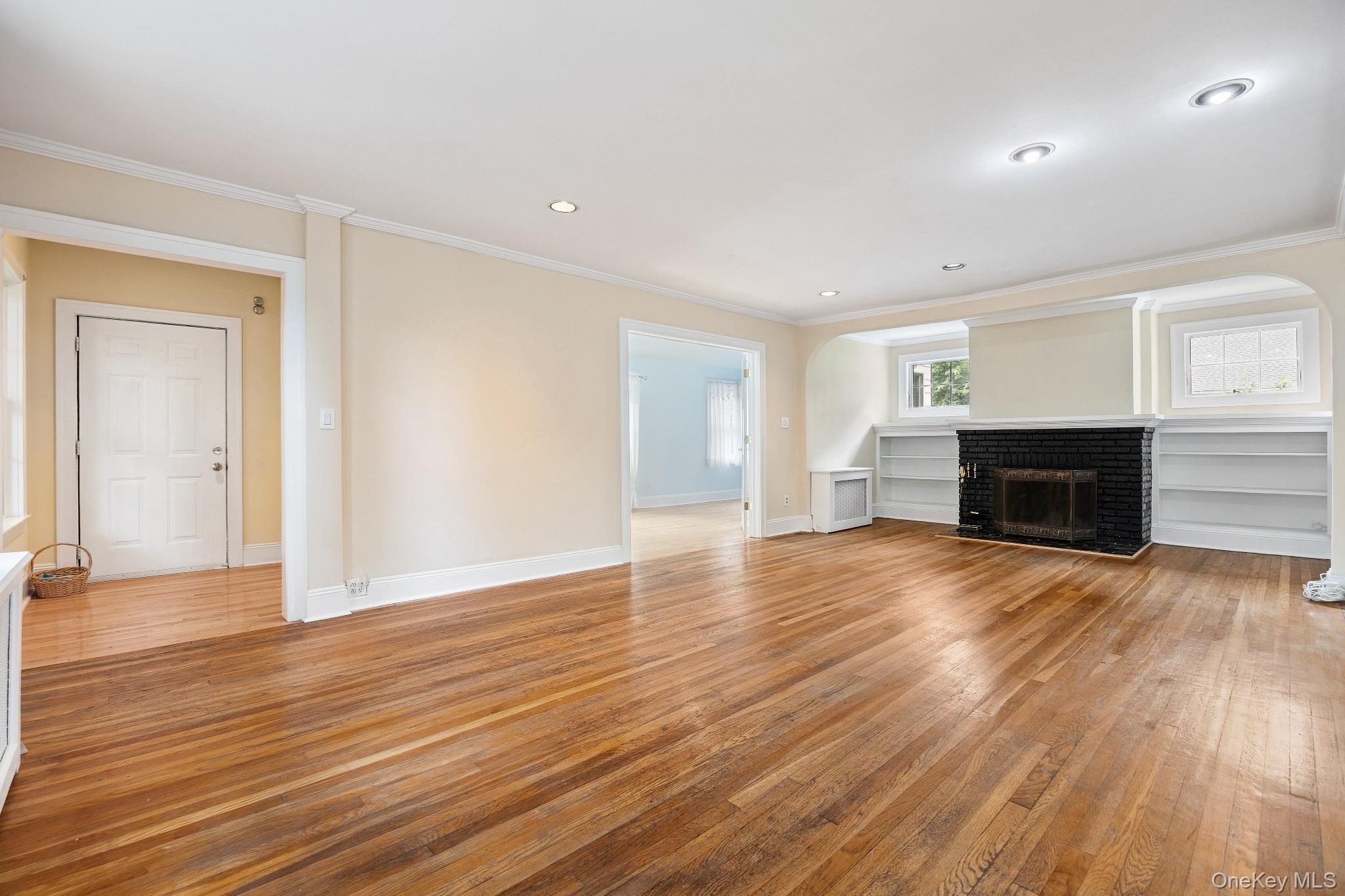 1235 Post Road Scarsdale, NY 10583 - Photo 6 of 30 Unfurnished living room with light wood-style flooring, ornamental molding, a brick fireplace, and recessed lighting