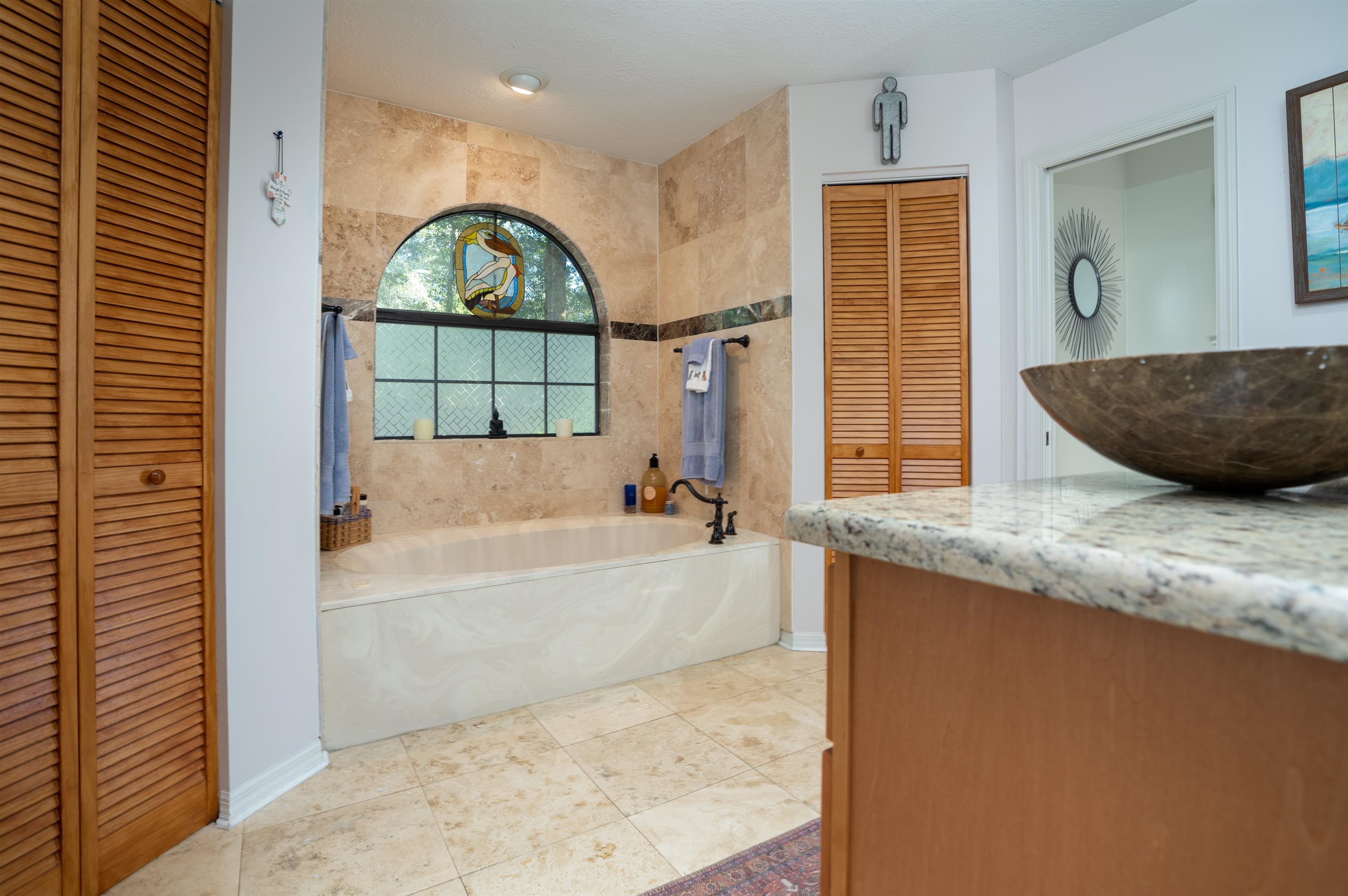 4260 Wicks Branch Road St. Augustine, FL 32086 - Photo 19 of 31 a bathroom with a granite countertop tub a sink and a large mirror
