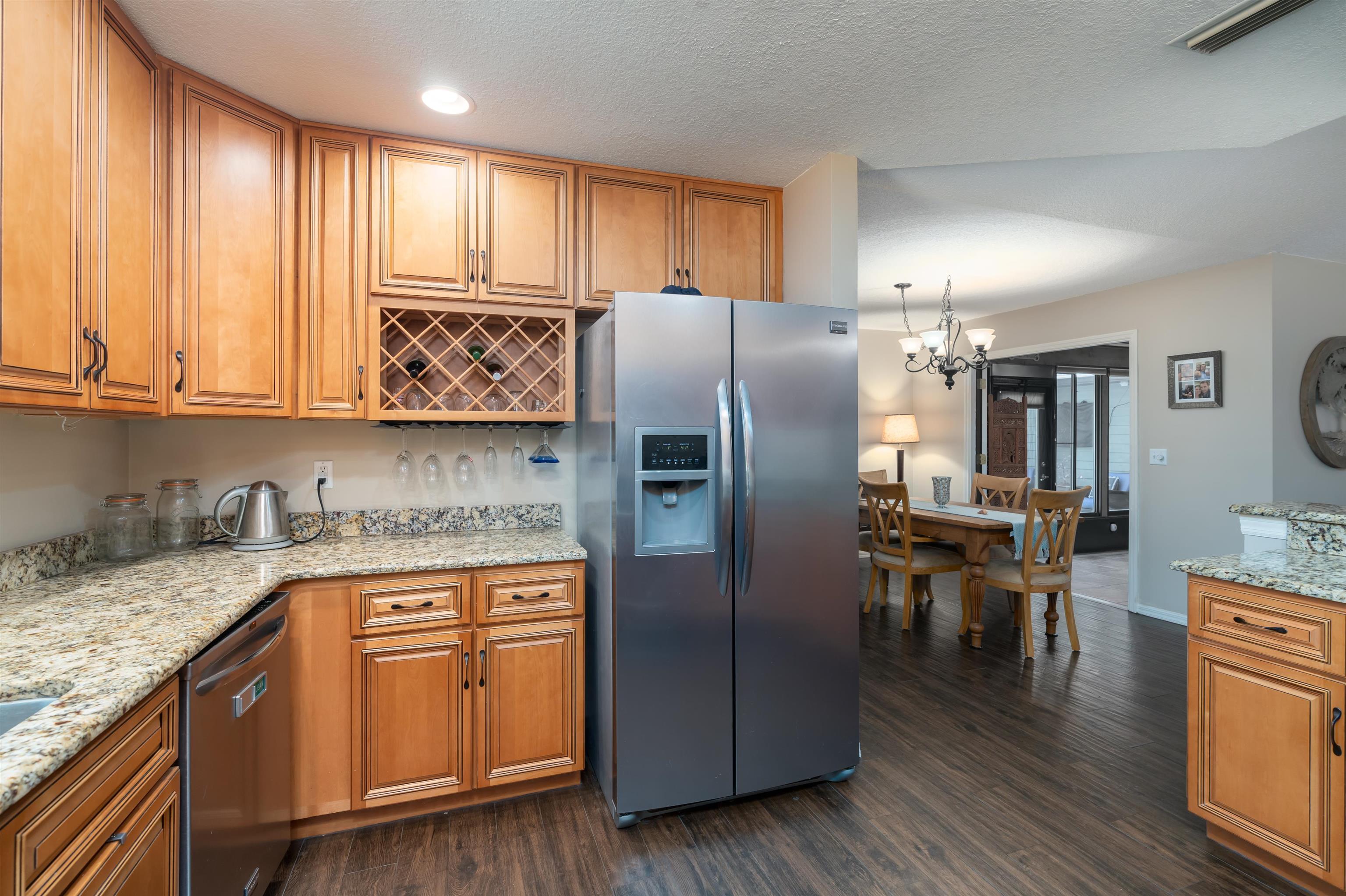 4260 Wicks Branch Road St. Augustine, FL 32086 - Photo 8 of 31 a kitchen with stainless steel appliances granite countertop a refrigerator a stove top oven a sink and dishwasher with wooden floor