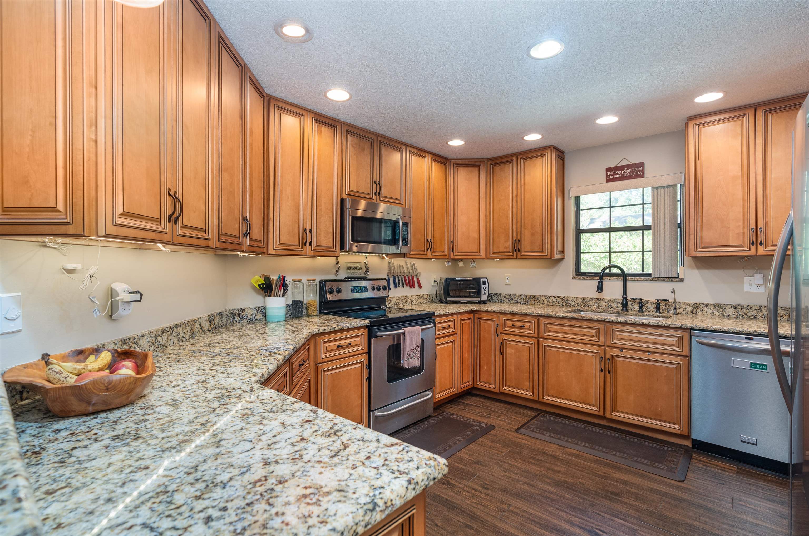 4260 Wicks Branch Road St. Augustine, FL 32086 - Photo 9 of 31 a kitchen with kitchen island granite countertop wooden cabinets a sink and appliances