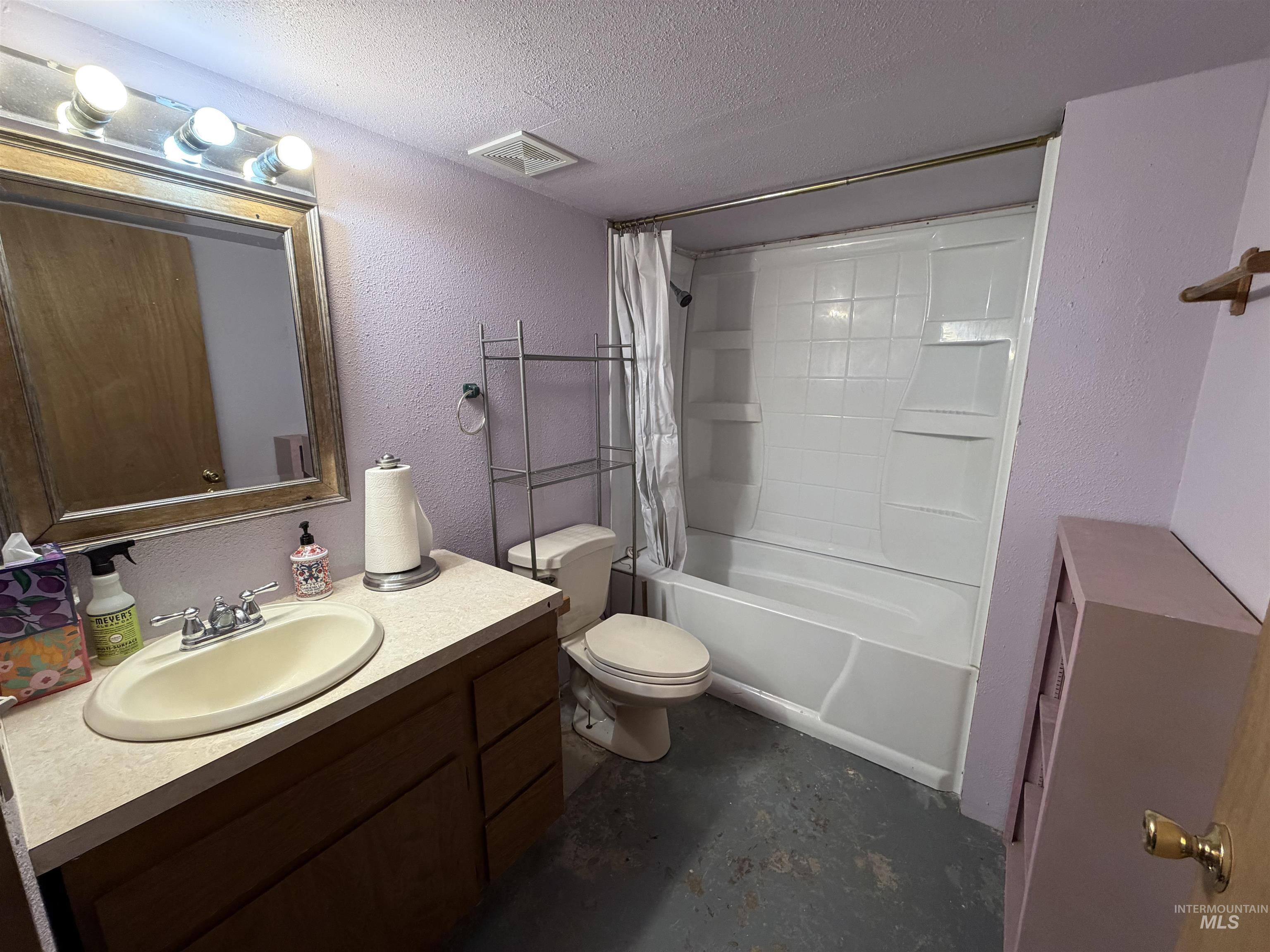 410 12th Street Lewiston, ID 83501 - Photo 27 of 38 Bathroom featuring a textured wall, vanity, a textured ceiling, concrete flooring, and shower / bath combination with curtain