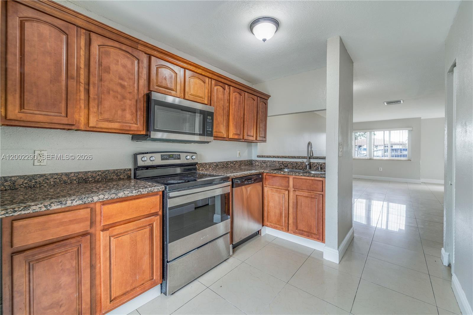 11310 Southwest 189th Street, Unit 11310 Miami, FL 33157 - Photo 2 of 24 a kitchen with stainless steel appliances granite countertop a stove microwave and cabinets