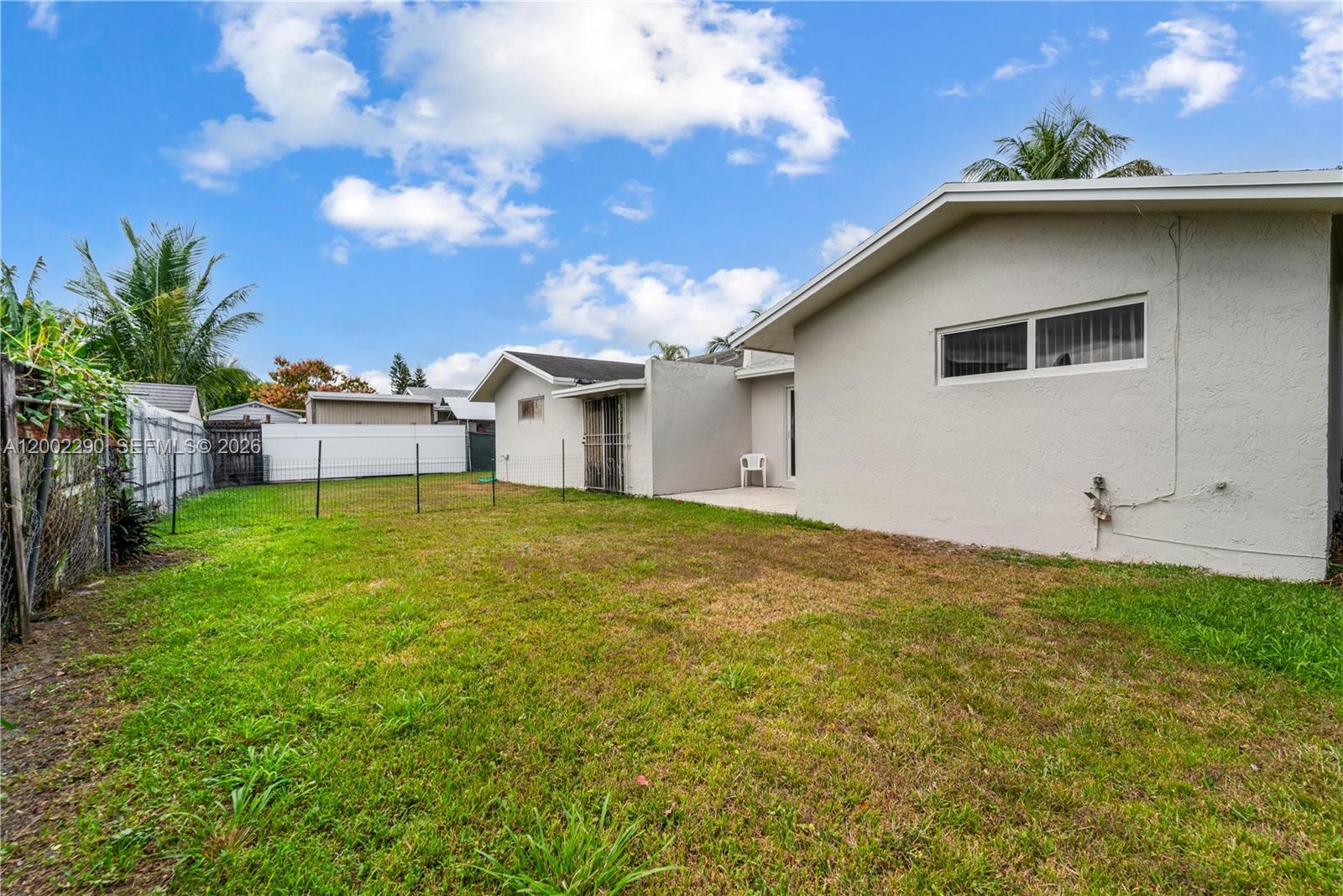 11310 Southwest 189th Street, Unit 11310 Miami, FL 33157 - Photo 21 of 24 a white house that has a big yard with wooden fence