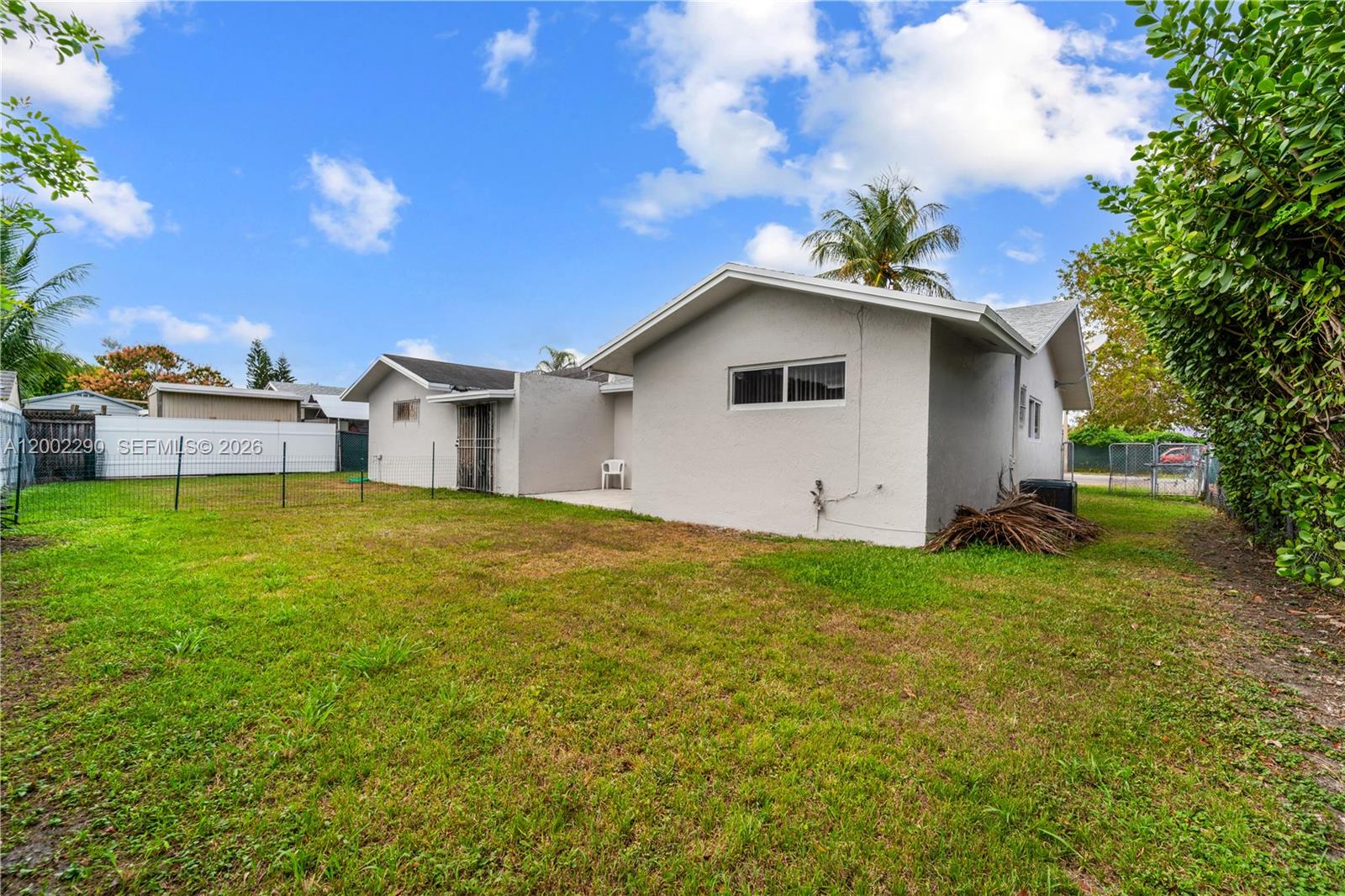11310 Southwest 189th Street, Unit 11310 Miami, FL 33157 - Photo 22 of 24 a white house that has a big yard with wooden fence