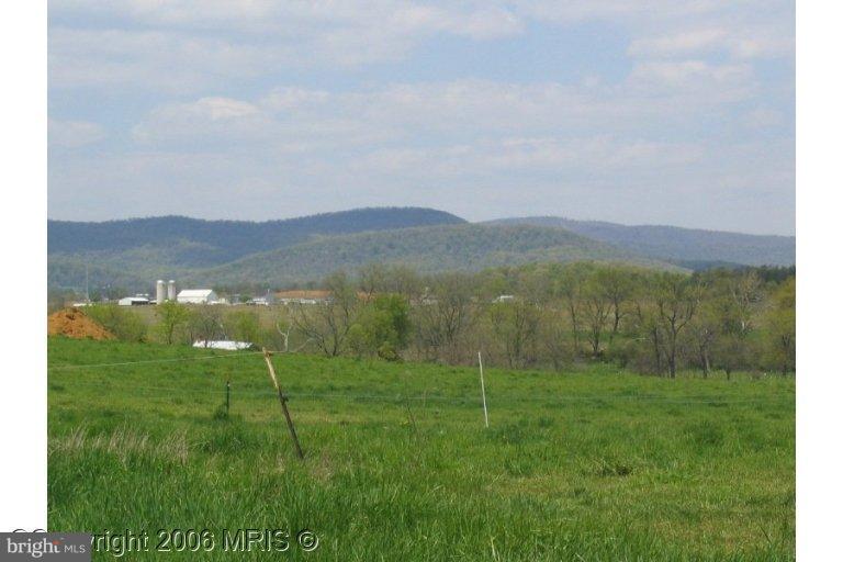 a view of grassy field with mountains in the background