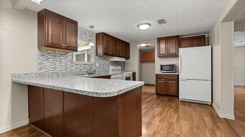 10379 Southwest 135 Street Archer, FL 32618 - Photo 14 of 45 a kitchen with kitchen island a sink appliances and cabinets