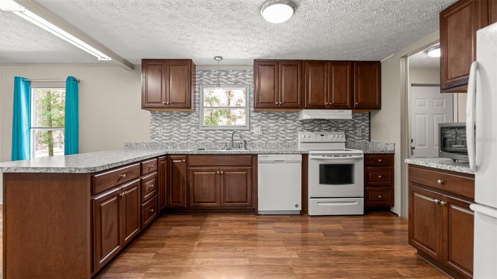 10379 Southwest 135 Street Archer, FL 32618 - Photo 15 of 45 a kitchen with stainless steel appliances granite countertop a stove and a sink