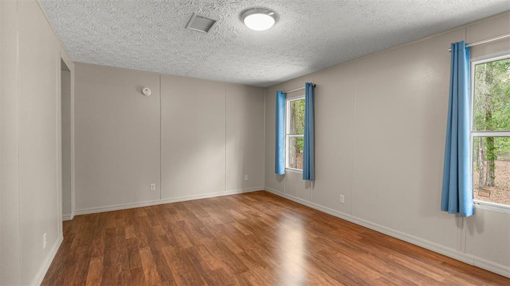 10379 Southwest 135 Street Archer, FL 32618 - Photo 18 of 45 an empty room with wooden floor and windows