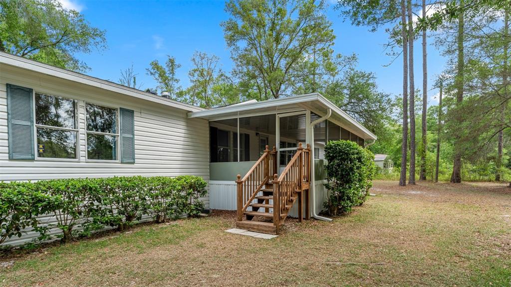 10379 Southwest 135 Street Archer, FL 32618 - Photo 2 of 45 a view of a house with a yard and potted plants
