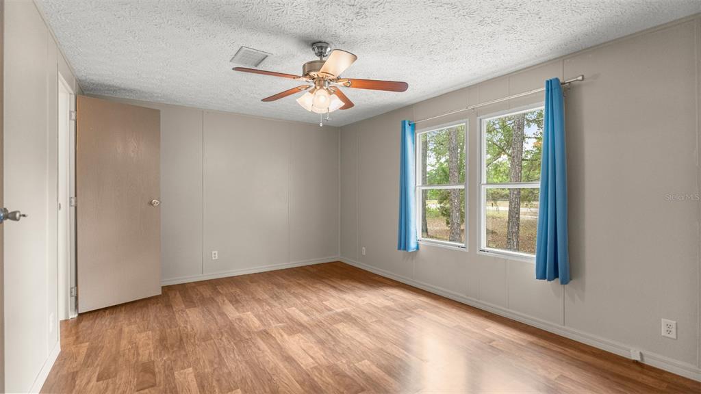 10379 Southwest 135 Street Archer, FL 32618 - Photo 25 of 45 a view of an empty room with wooden floor and a window