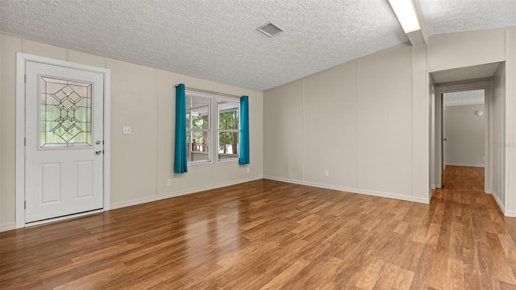 10379 Southwest 135 Street Archer, FL 32618 - Photo 6 of 45 a view of an empty room with wooden floor and a window