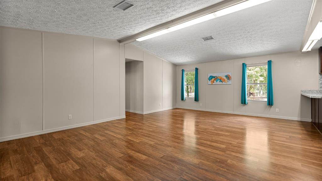 10379 Southwest 135 Street Archer, FL 32618 - Photo 8 of 45 a view of an empty room with window and wooden floor