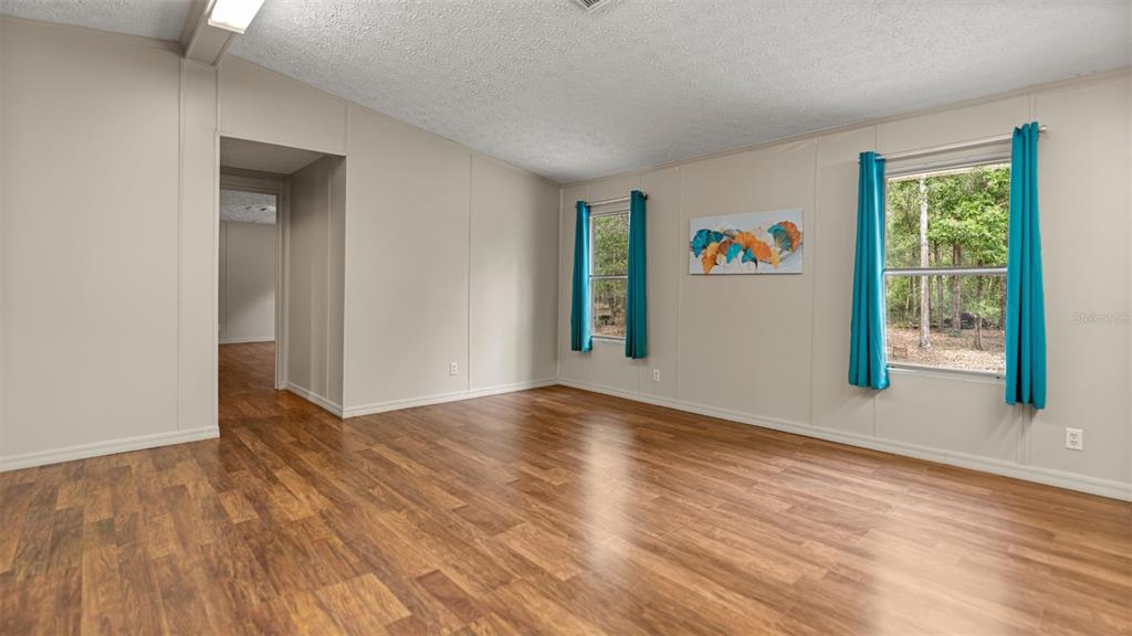 10379 Southwest 135 Street Archer, FL 32618 - Photo 9 of 45 a view of an empty room with wooden floor and a window