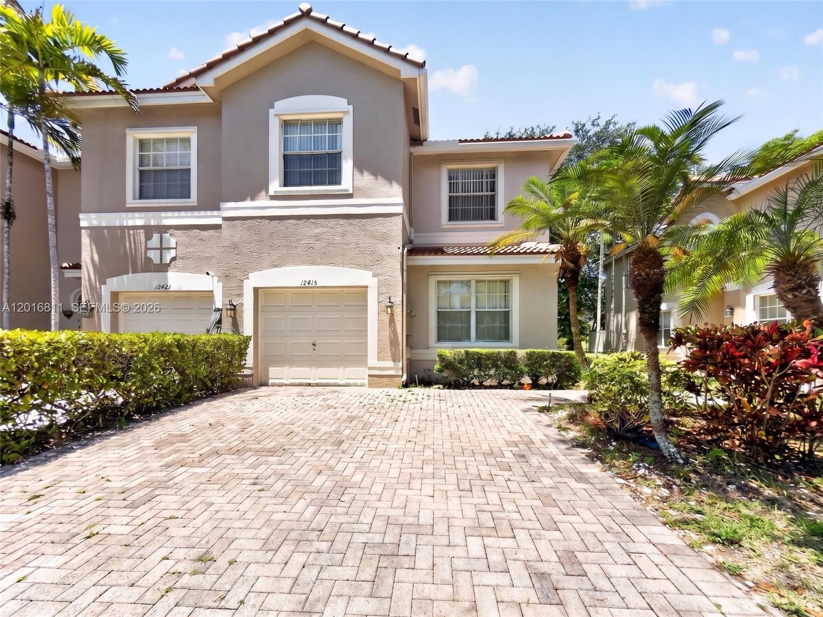 12415 Southwest 42nd Street Miramar, FL 33027 - Photo 1 of 21 a front view of a house with a yard and garage