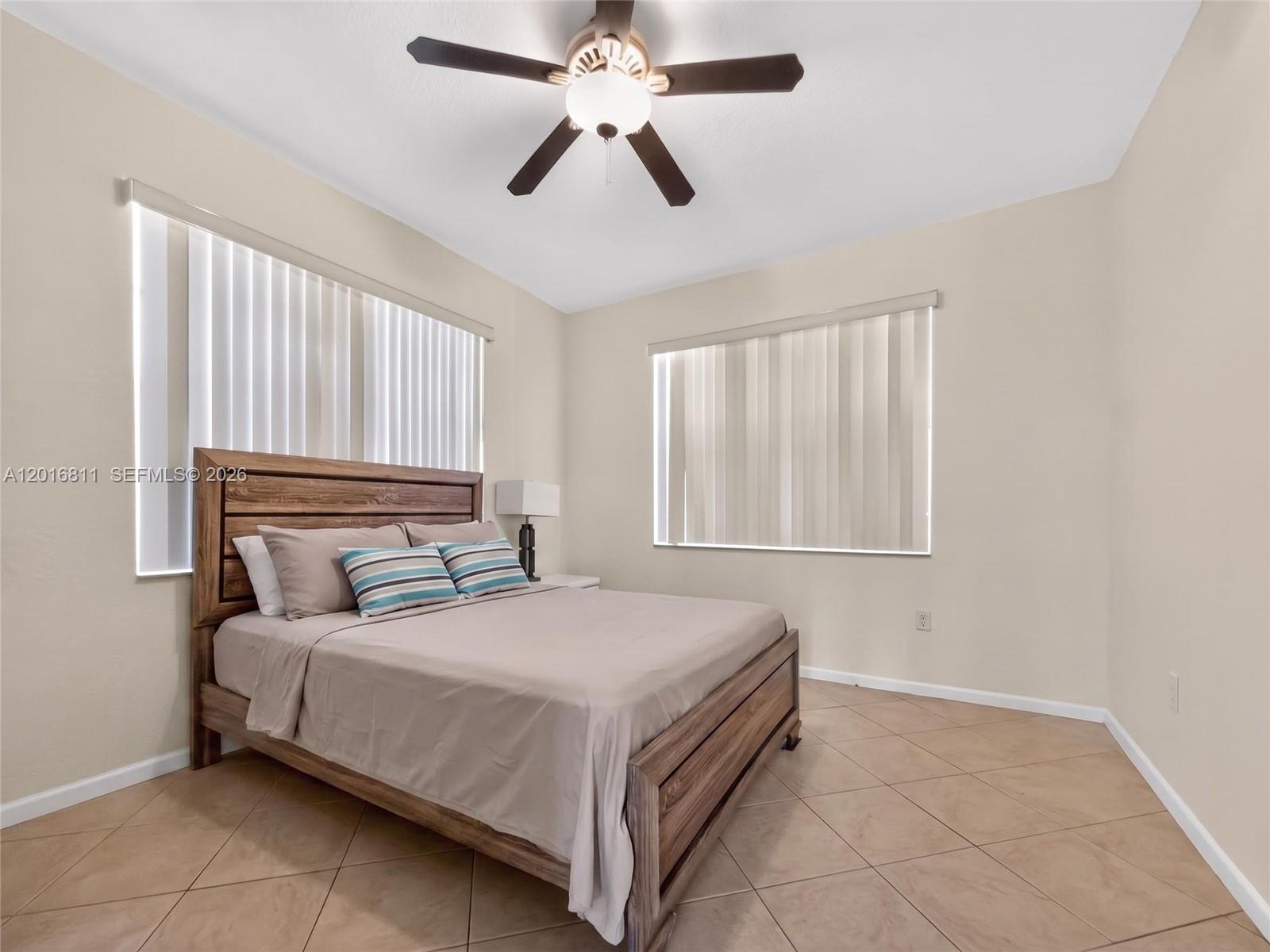 12415 Southwest 42nd Street Miramar, FL 33027 - Photo 11 of 21 a bedroom with a bed and a ceiling fan