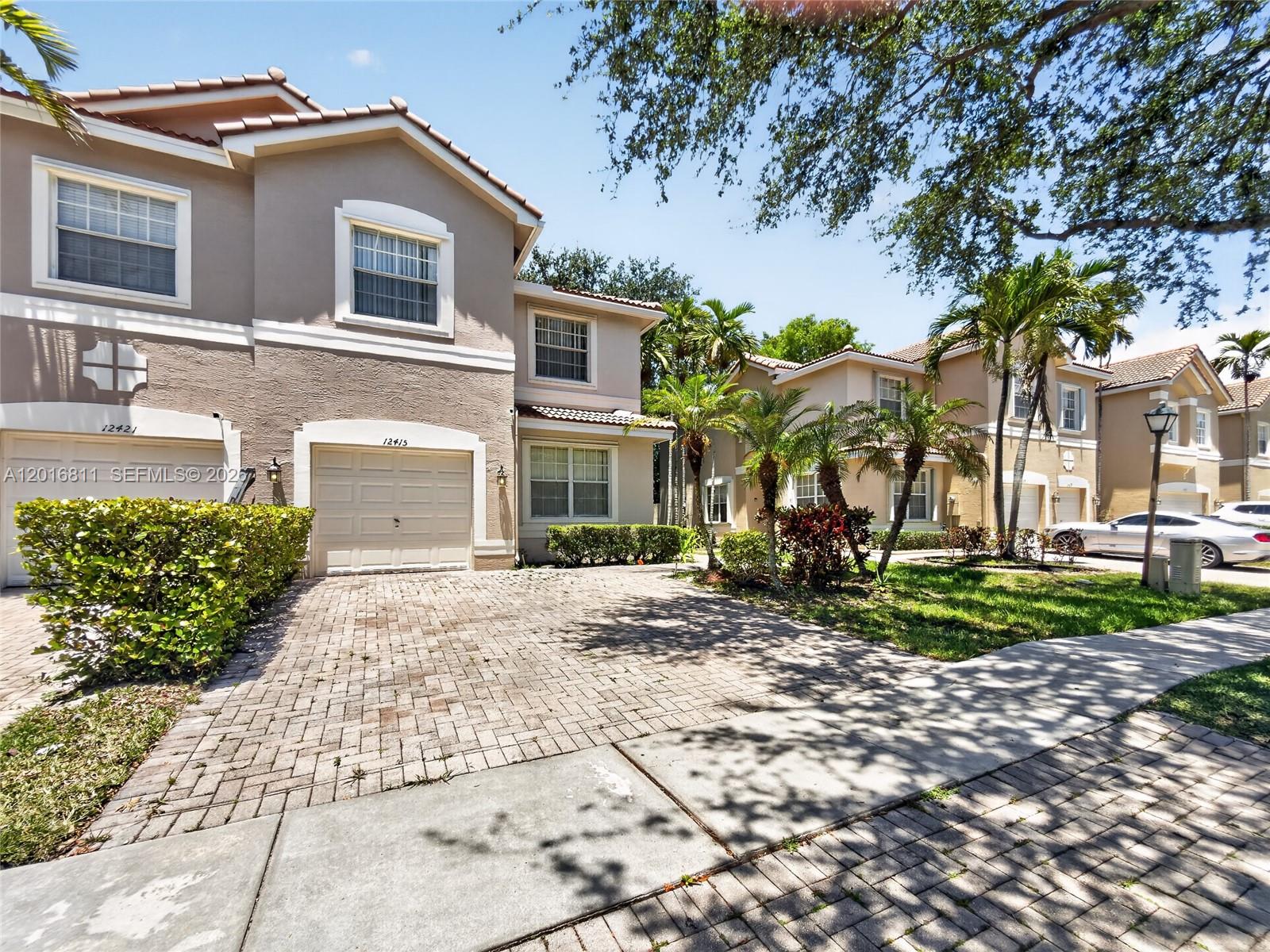 12415 Southwest 42nd Street Miramar, FL 33027 - Photo 2 of 21 a front view of a house with a yard and potted plants
