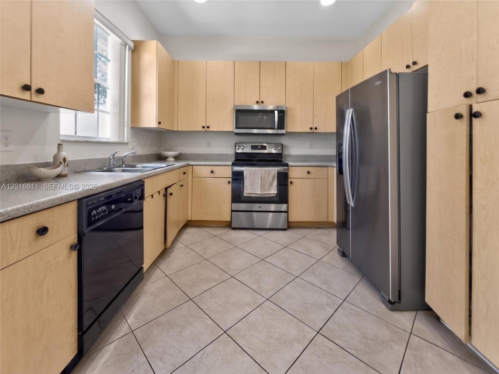 12415 Southwest 42nd Street Miramar, FL 33027 - Photo 5 of 21 a kitchen with a refrigerator sink and cabinets